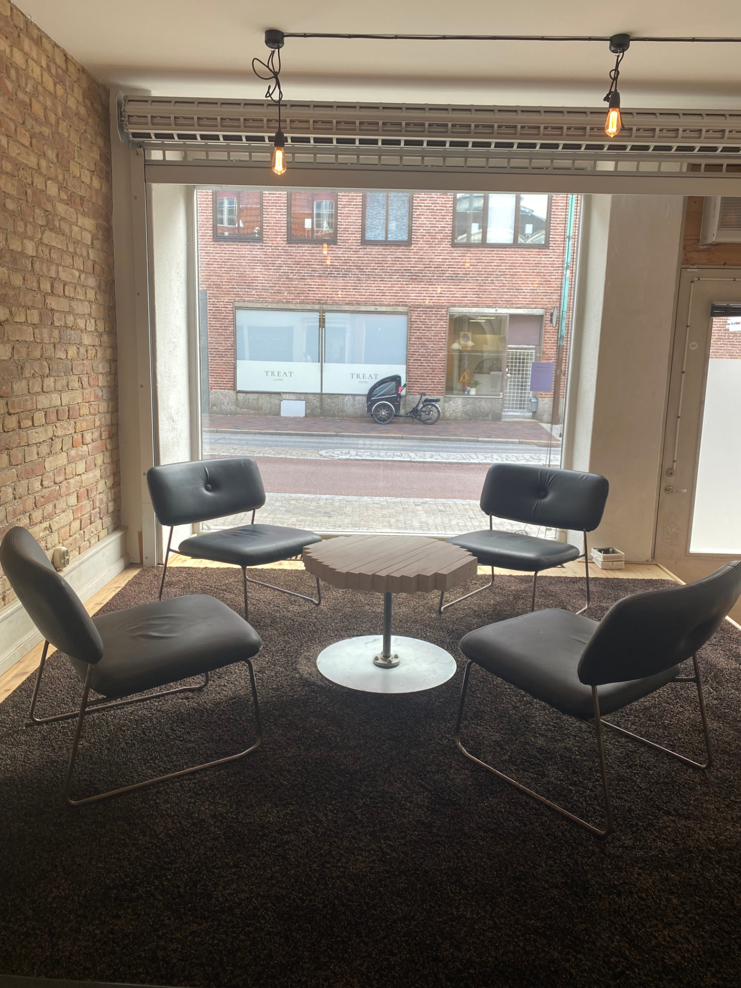 Lounge seating by the street window with exposed brick wall