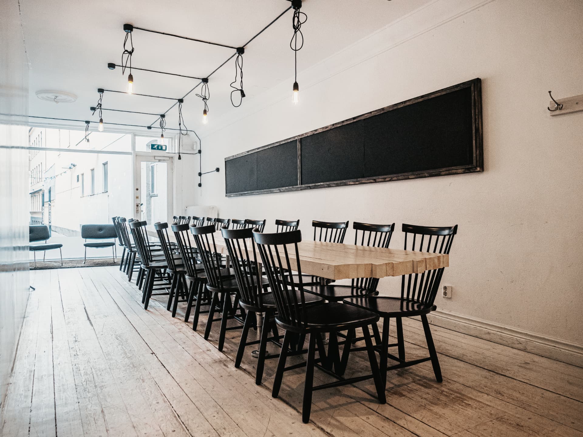 Meeting room with a long wooden table and black chairs